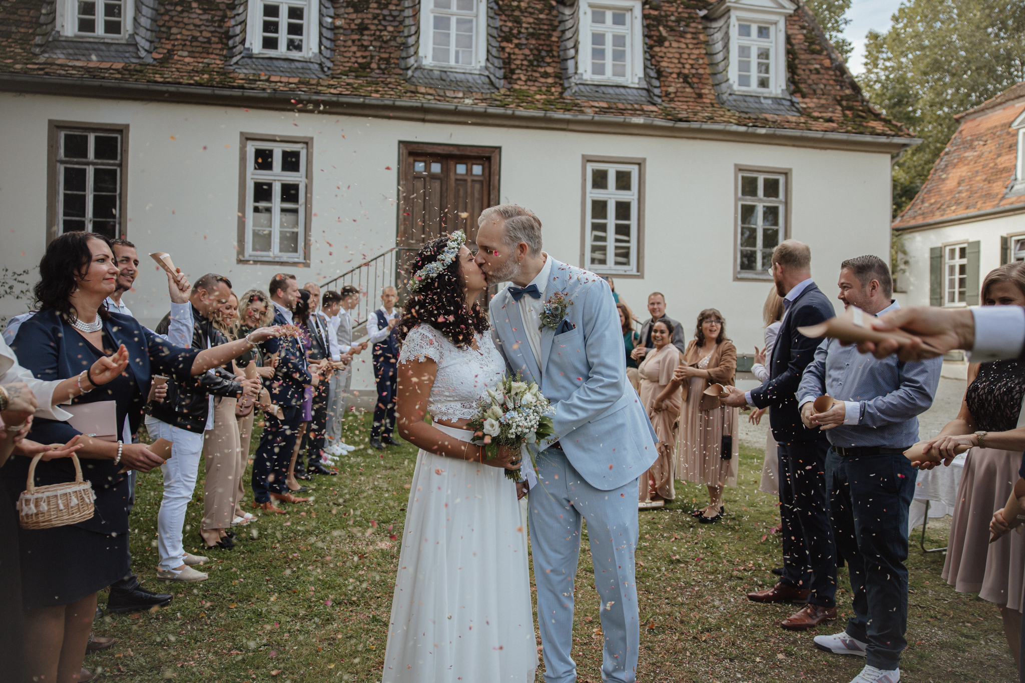 Hochzeit Jagdschloss Mönchbruch Brautpaar draußen Gäste Brautpaarkuss