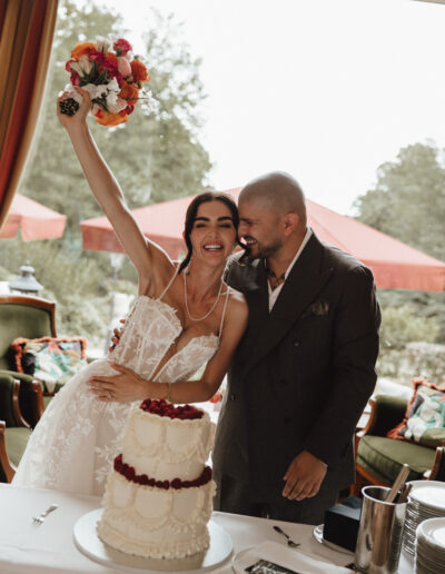 Braut jubelt beim Anschneiden der Hochzeitstorte, deutsch-persische Hochzeit im Taunus